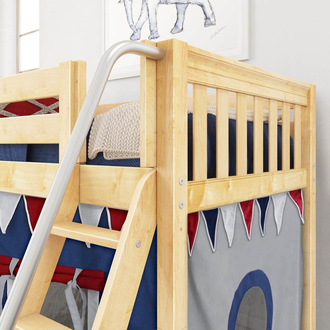 Wooden bunk bed with ladder in a child's room decorated with nautical-themed fabric and blue cushions.