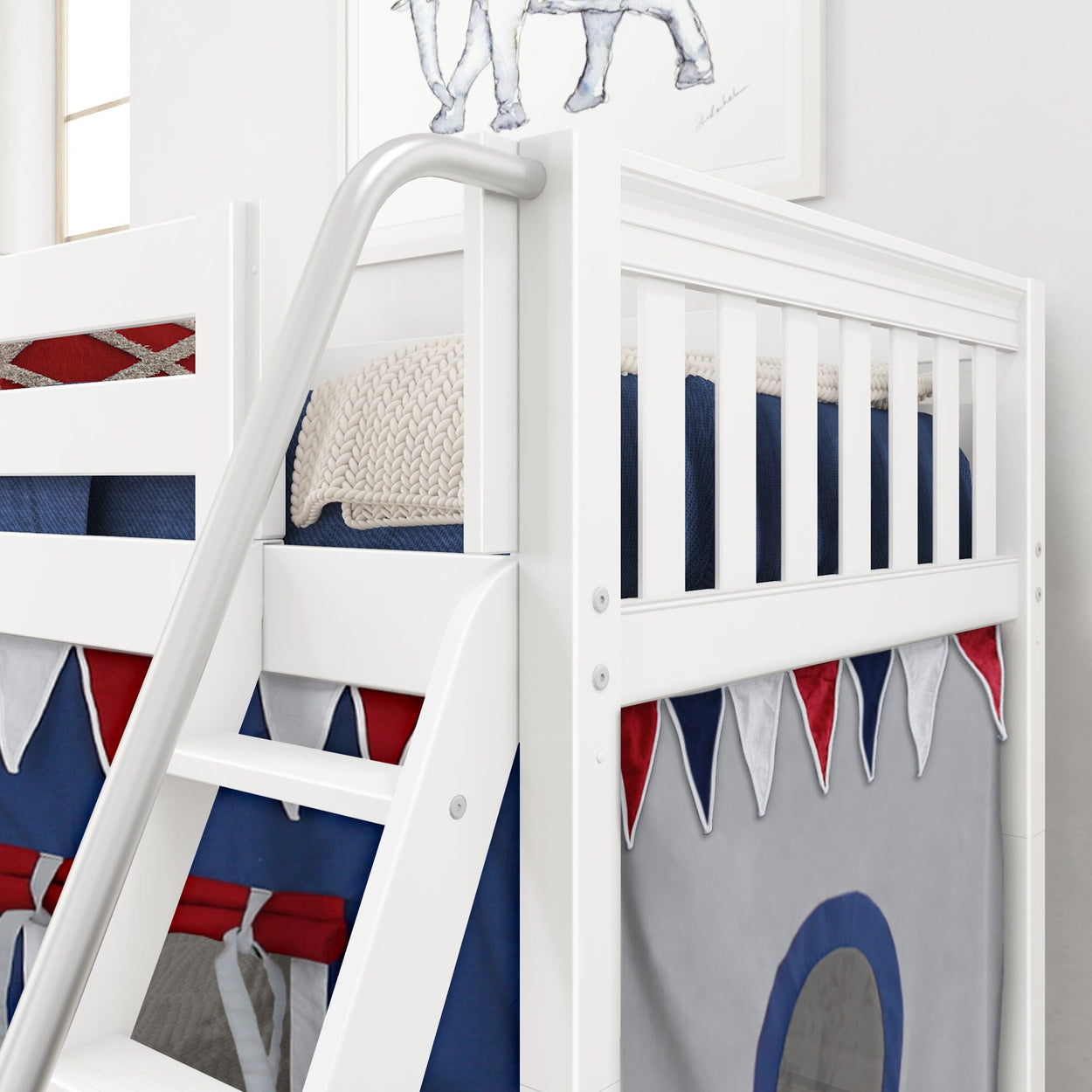 White wooden bunk bed with a colorful playhouse curtain, cozy navy and red bedding, and a knit blanket, featuring a slide ladder for kids' room.
