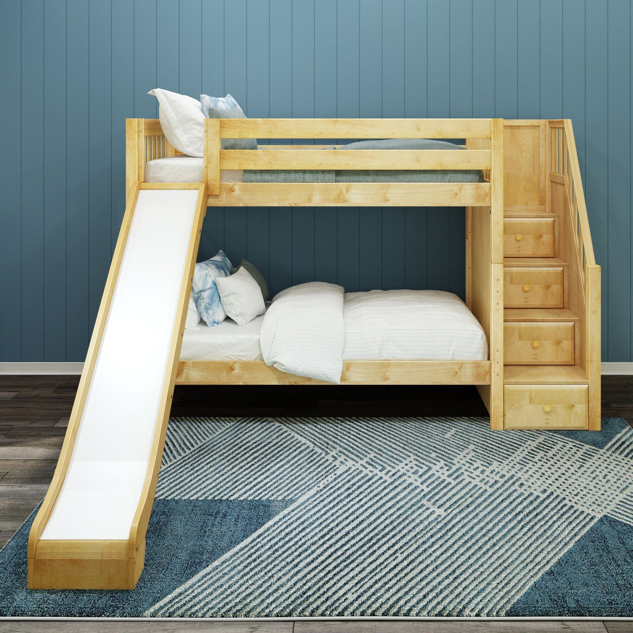 Wooden bunk bed with slide and stairs, featuring blue and white bedding, in a children's room with patterned carpet and blue walls.