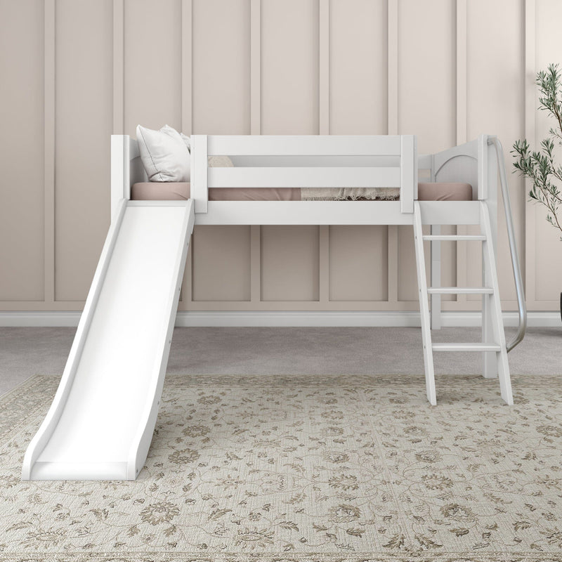 White kids loft bed with slide and ladder, blush bedding and pillows against beige paneled wall, minimalist children's bedroom decor
