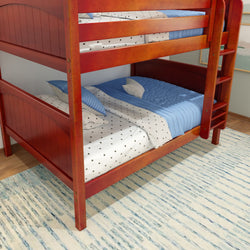 Wooden bunk bed with blue bedding and star-patterned sheets in a modern bedroom.