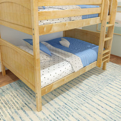 Wooden bunk bed with blue and white star-patterned bedding in a cozy bedroom setting.