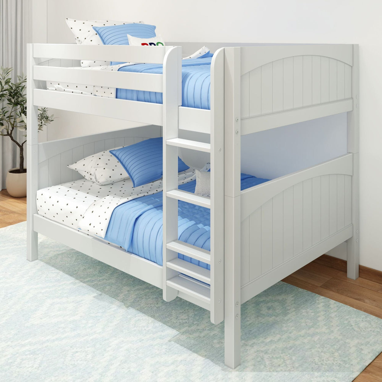 White wooden bunk bed with blue bedding and polka dot sheets in a bright children's room.