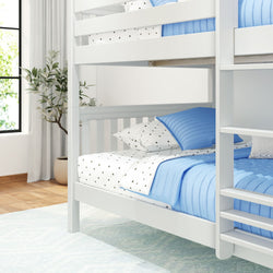 Modern white bunk bed with blue bedding and star-patterned sheets in a bright, cozy bedroom.