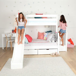 Girl enjoying a slide on white bunk bed with storage, next to a study desk, in a playful children's bedroom.