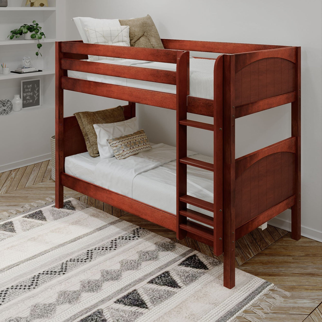 Wooden bunk bed with white bedding and decorative pillows in a cozy bedroom with geometric-patterned rug.
