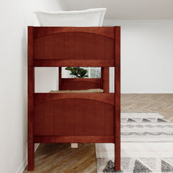 Red wooden bunk bed with white bedding in a modern minimalistic room featuring hardwood floors and geometric patterned rug.