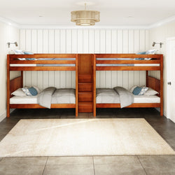Four wooden bunk beds with gray bedding in a cozy, white-paneled bedroom featuring a warm, minimalist design.