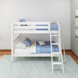 White wooden bunk bed with blue bedding and polka dot pillows in a modern children's room.