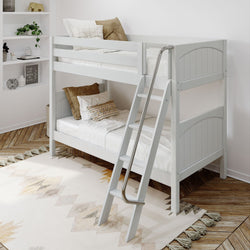 Modern white wooden bunk bed with ladder in cozy bedroom setting.