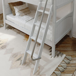 White bunk bed with ladder in a modern bedroom setting on a patterned rug.