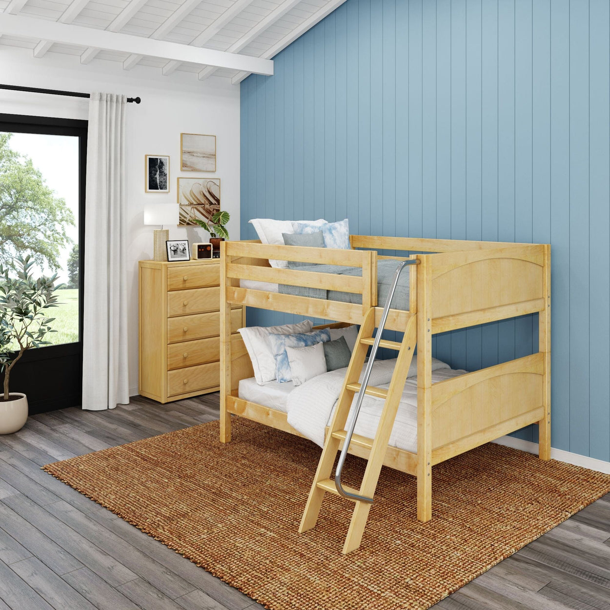Modern children's bedroom with wooden bunk bed, blue accent wall, and natural light.
