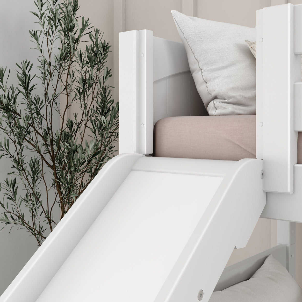 White children's bed with a slide and beige pillow set, next to a potted plant, ideal for playful bedroom decor.