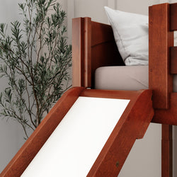 Wooden loft bed with slide and storage, featuring white cushion and indoor plant for modern children's bedroom decor.