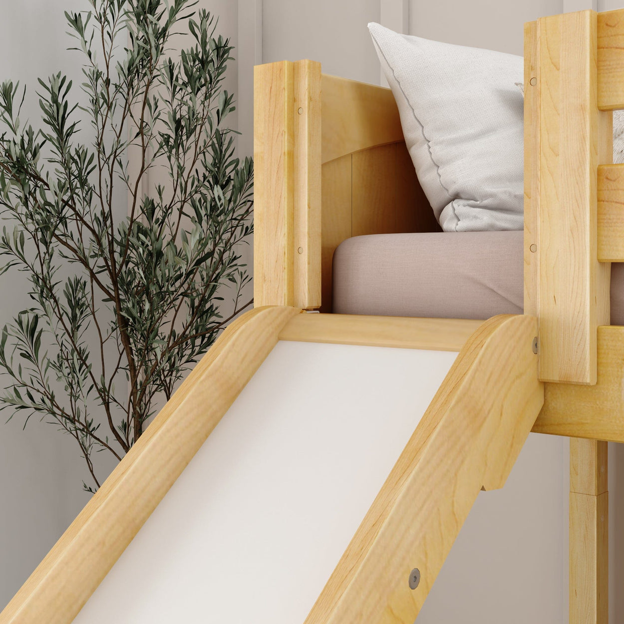 Wooden loft bed with slide and cozy pillows next to a decorative plant in a modern room.