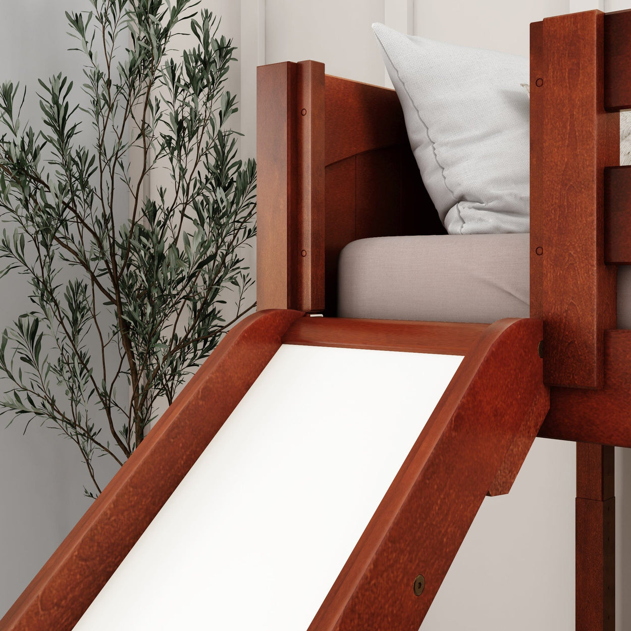 Wooden loft bed with slide and tree decor in modern bedroom.