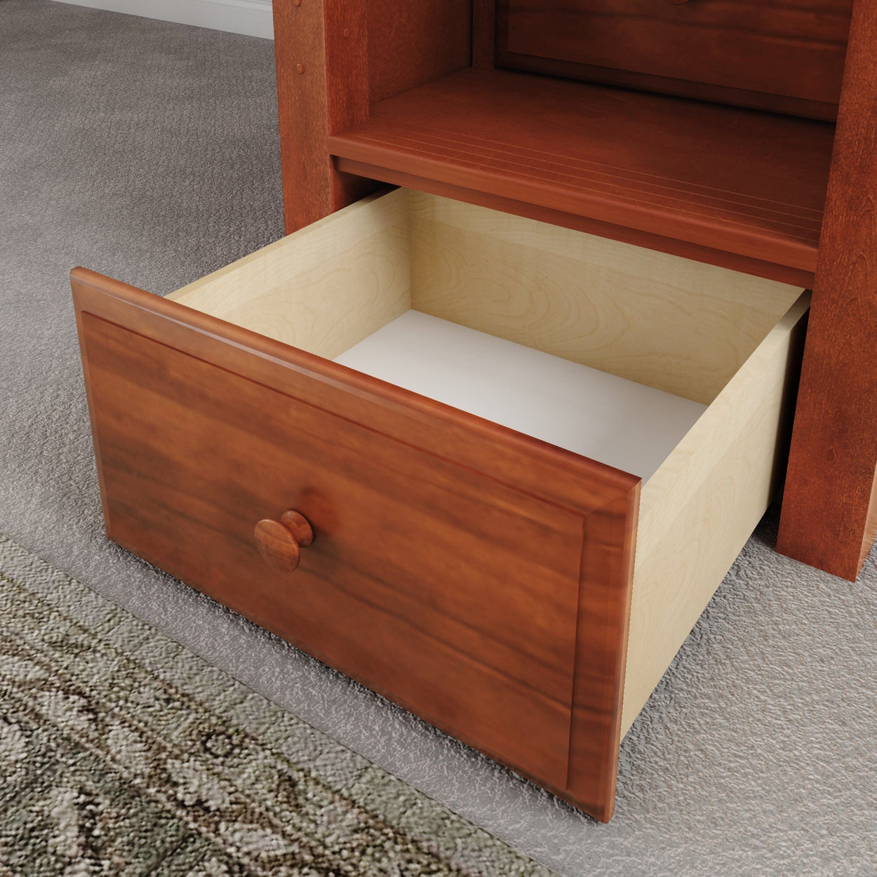 Open wooden drawer showing interior in a carpeted room.