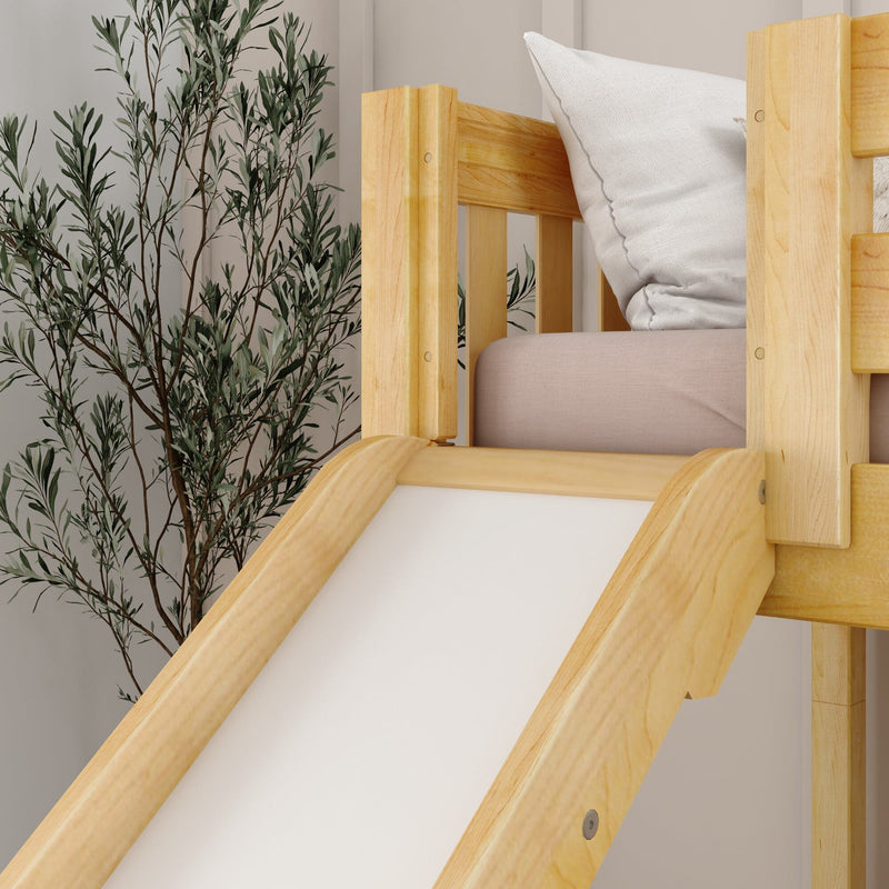 Natural wood children's loft bed with built-in slide, white pillow and blush mattress beside indoor greenery on a neutral nursery wall