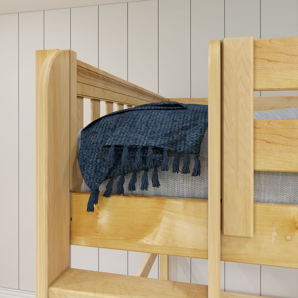 Wooden bunk bed with blue tassel blanket in modern bedroom setting.
