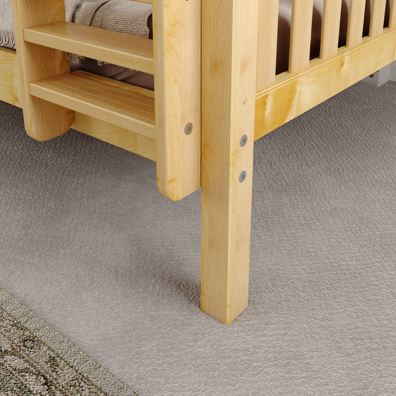 Close-up of natural pine wooden bed frame corner with slatted headboard, visible metal bolts, beige mattress and textured gray carpet