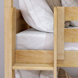 Wooden bunk bed frame with cozy blankets and pillows.