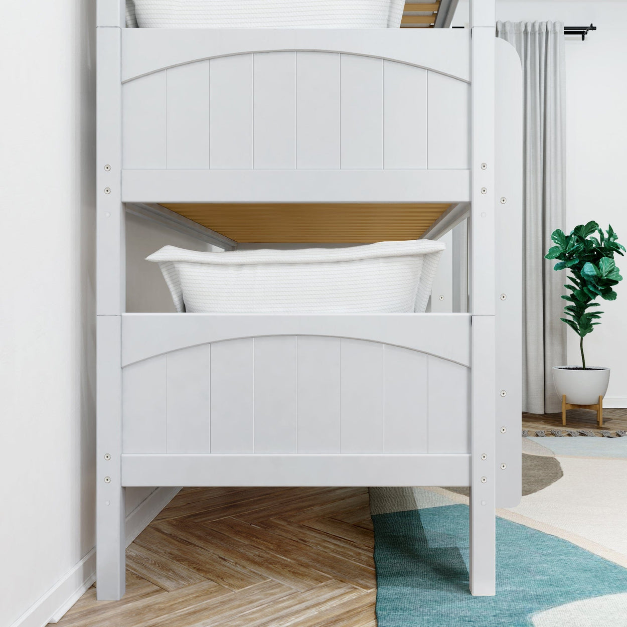 Modern white bunk bed in a cozy bedroom with a green potted plant and stylish wooden floor.
