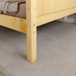 Wooden bed frame corner with beige carpet flooring.