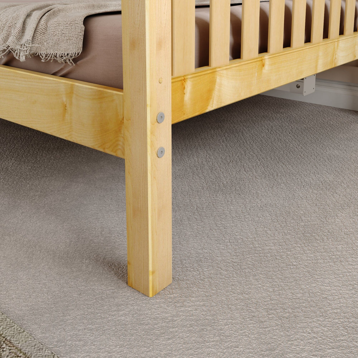 Wooden bed frame leg on carpeted floor with beige blanket.