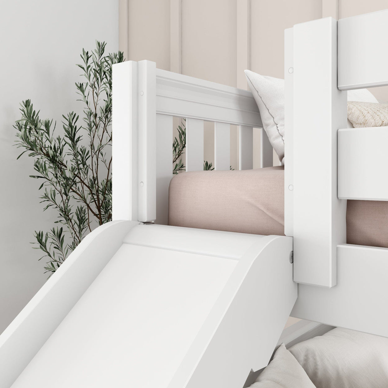 White children's bunk bed with slide and pink bedding, surrounded by decorative plants in a modern bedroom.