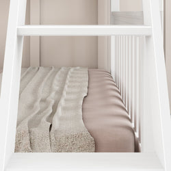Luxurious white bunk bed with soft beige bedding and textured blanket in elegant bedroom setting.