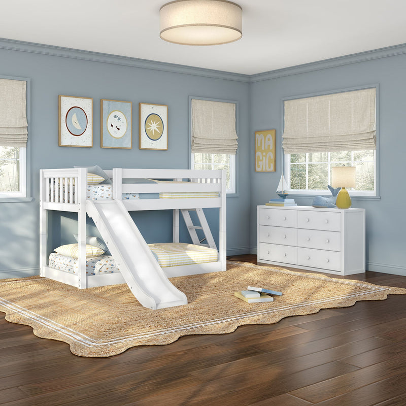 Children's coastal bedroom with white bunk bed and slide, blue walls, framed art, white dresser, jute rug, Roman shades and wood floors