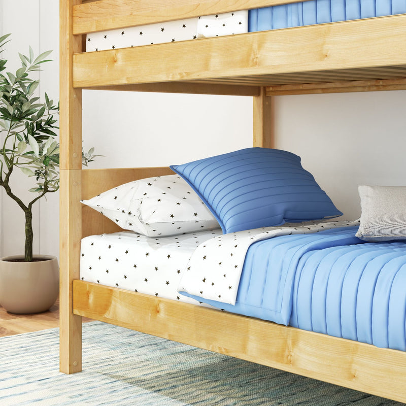 Natural wood bunk bed with blue quilted bedding and star-print white sheets in a modern kids' bedroom with a potted plant