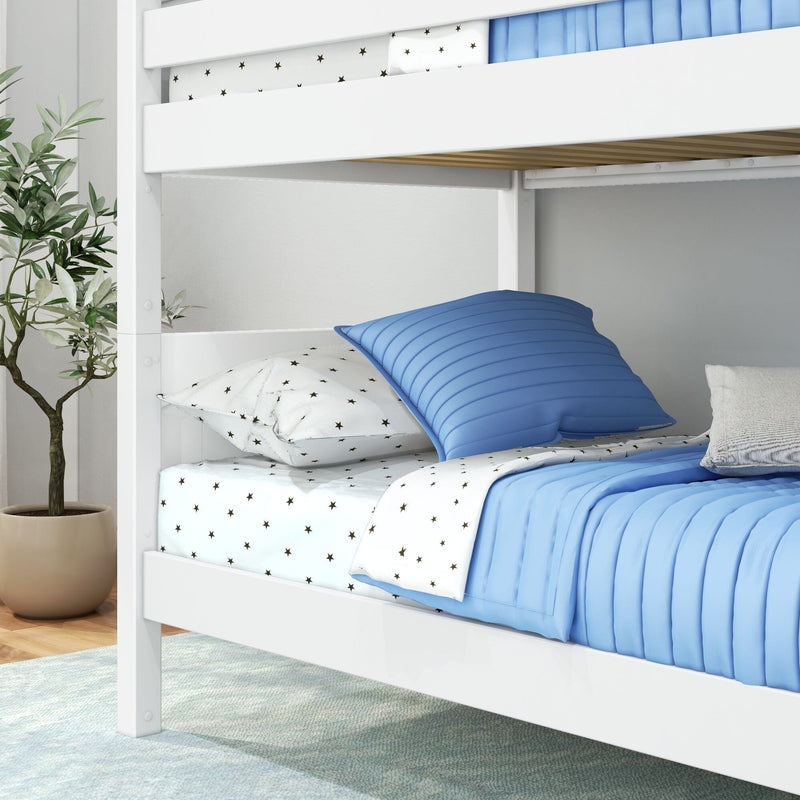 White wooden bunk bed with blue quilted bedding and star-print sheets in modern kids' bedroom with potted plant