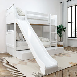 White wooden bunk bed with slide, ladder and pull-out trundle in a modern children's bedroom with neutral rug and potted plant by a large window