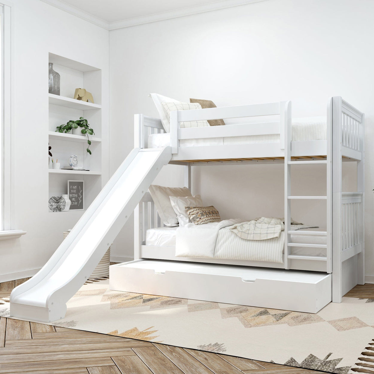 White wooden bunk bed with slide and trundle drawer in a bright modern children's bedroom with neutral bedding, ladder and built-in shelving