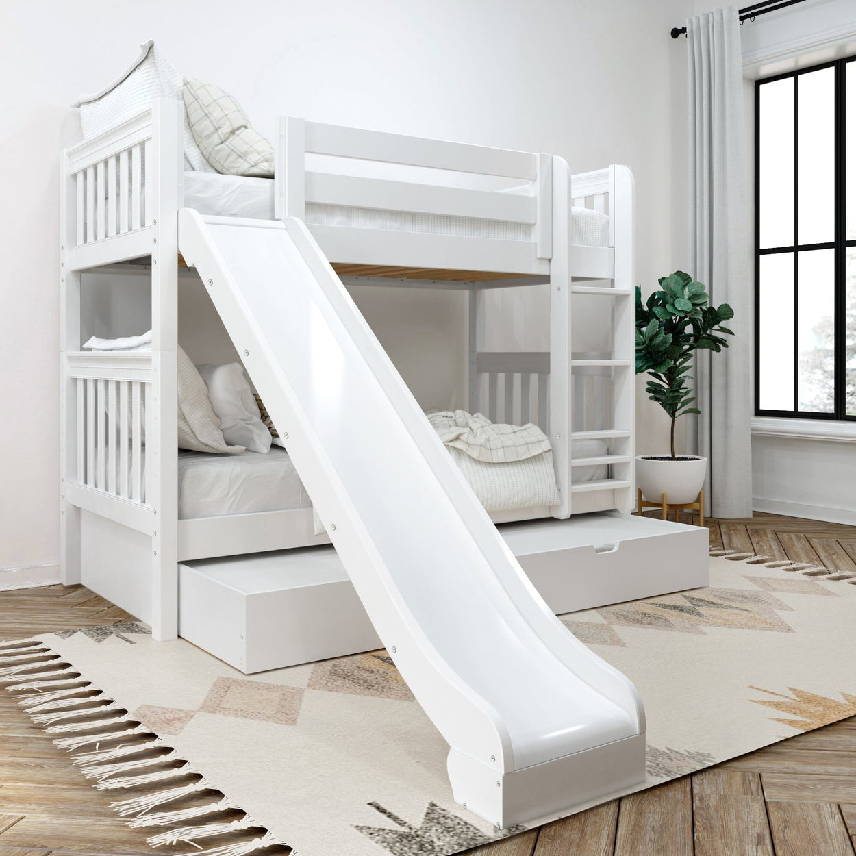 White wooden twin-over-twin bunk bed with slide, ladder and under-bed storage drawer in a modern kids' bedroom with large window and plant
