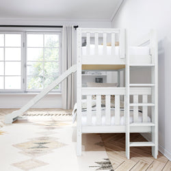 White bunk bed with a slide and ladder in a bright children's bedroom with large windows and light wood flooring.