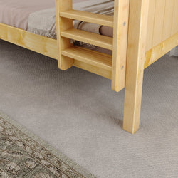Natural wood bunk bed corner with ladder on plush carpet, featuring a soft beige blanket, enhancing cozy bedroom aesthetics.