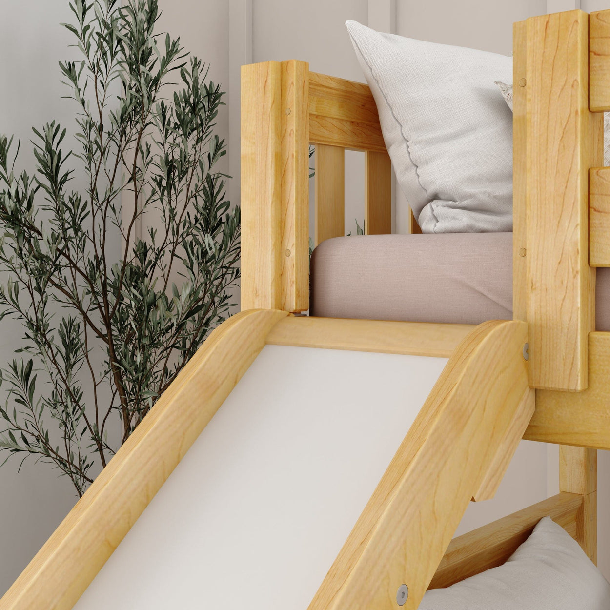 Wooden bunk bed with slide and cushion in cozy bedroom setting.