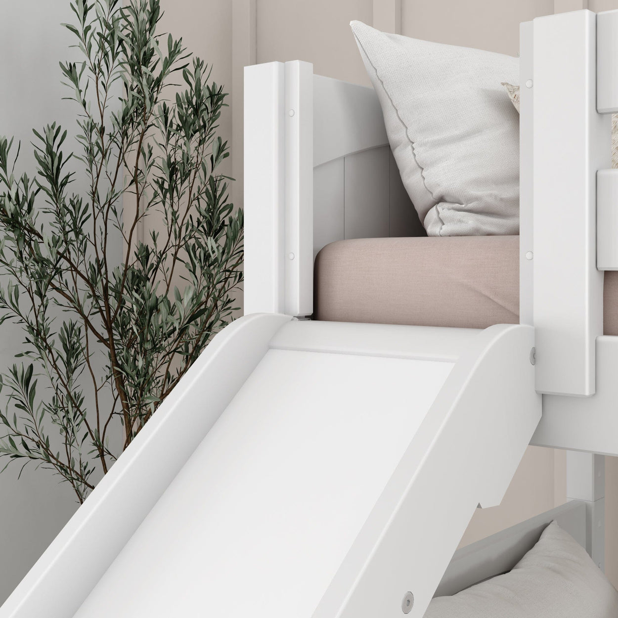 White loft bed with slide and pink bedding, adjacent to a green indoor plant, in a modern bedroom setting.