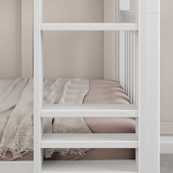 White bunk bed with beige bedding and textured blanket in modern minimalist bedroom.