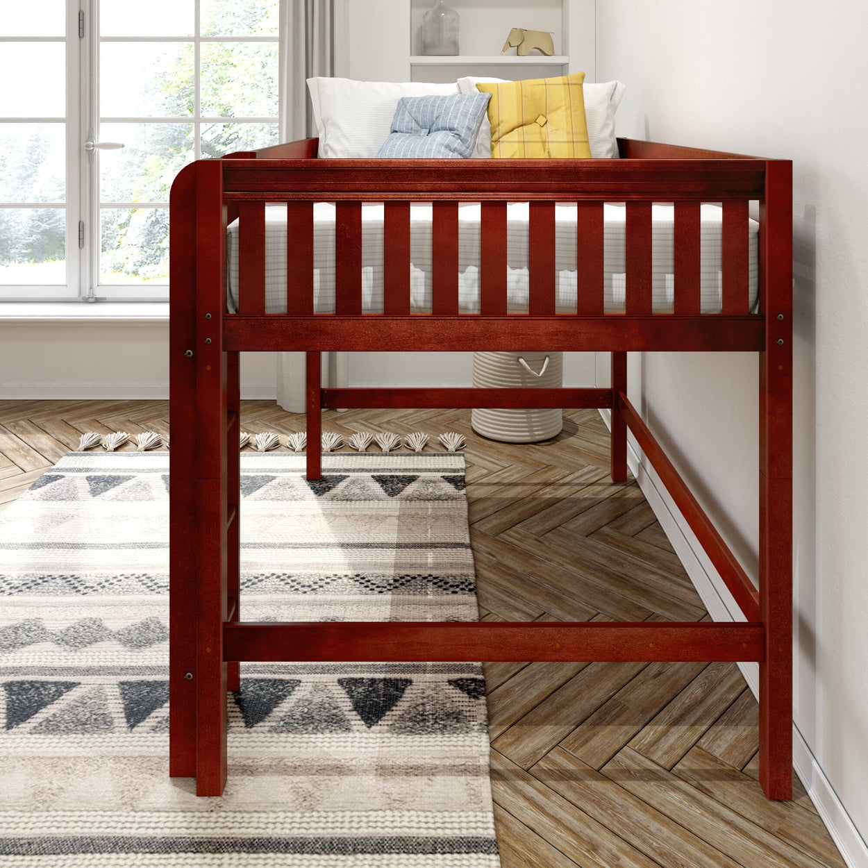 Red wooden twin loft bed with white mattress and decorative pillows in a bright kids bedroom featuring a geometric area rug and herringbone hardwood floor