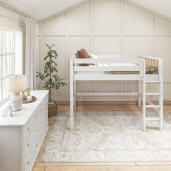 Bright neutral children's bedroom with white loft bed and ladder, white dresser and lamp, potted plant, patterned area rug, hardwood floors, modern farmhouse style