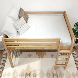 Twin loft bed in natural pine with ladder and white bedding, a space-saving wooden raised bed frame in a minimalist children's bedroom with boho rug and potted plant
