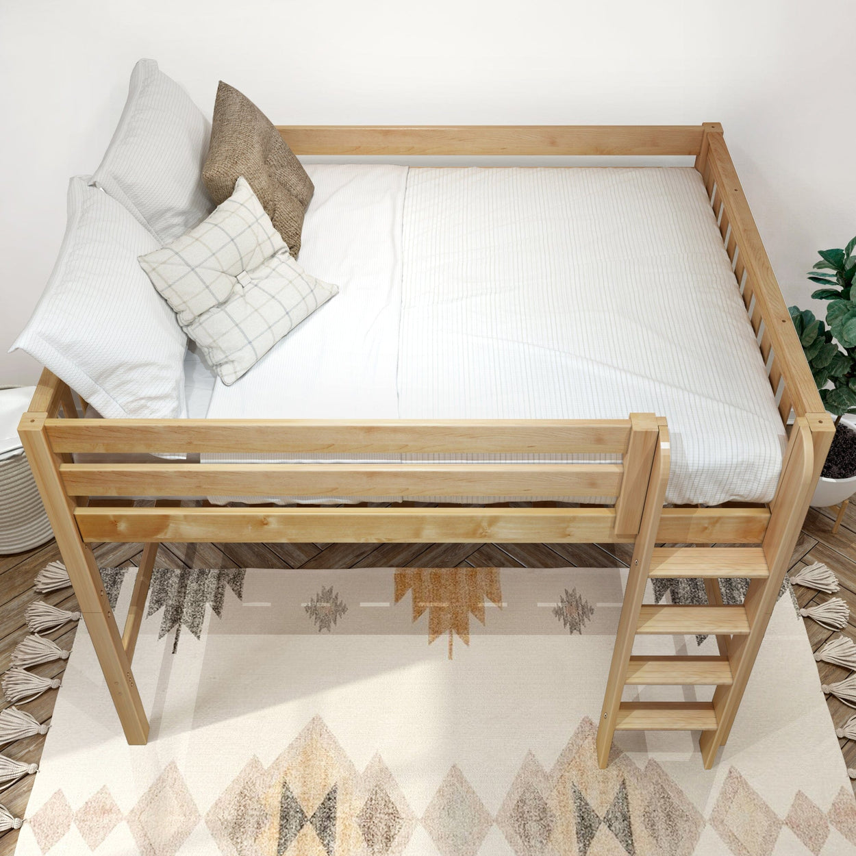 Natural wood loft bed with ladder, white bedding and decorative pillows in a minimalist bedroom with geometric rug and potted plant