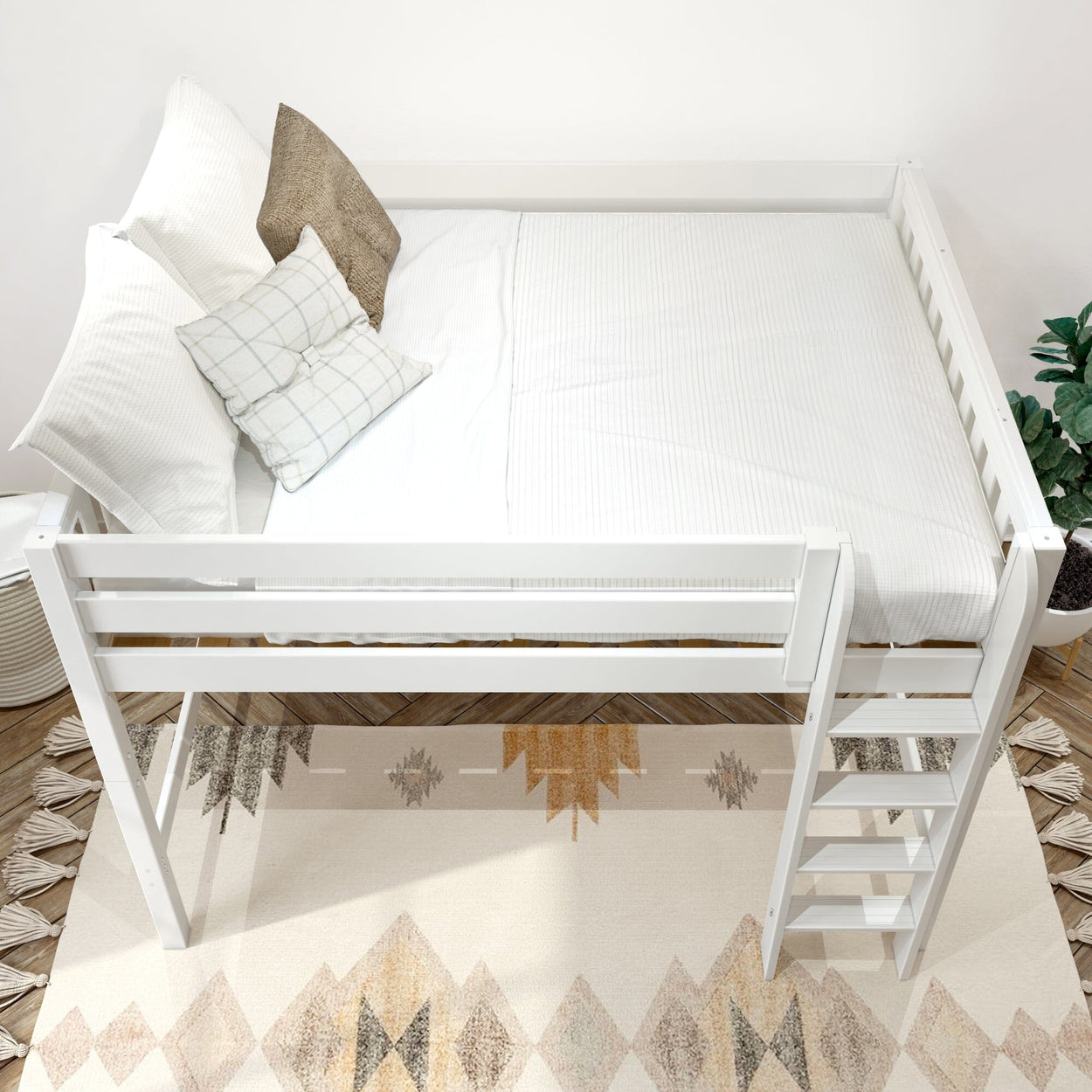 White space-saving loft bed with ladder, crisp white bedding and patterned throw pillows in a modern neutral bedroom with geometric area rug and potted plant