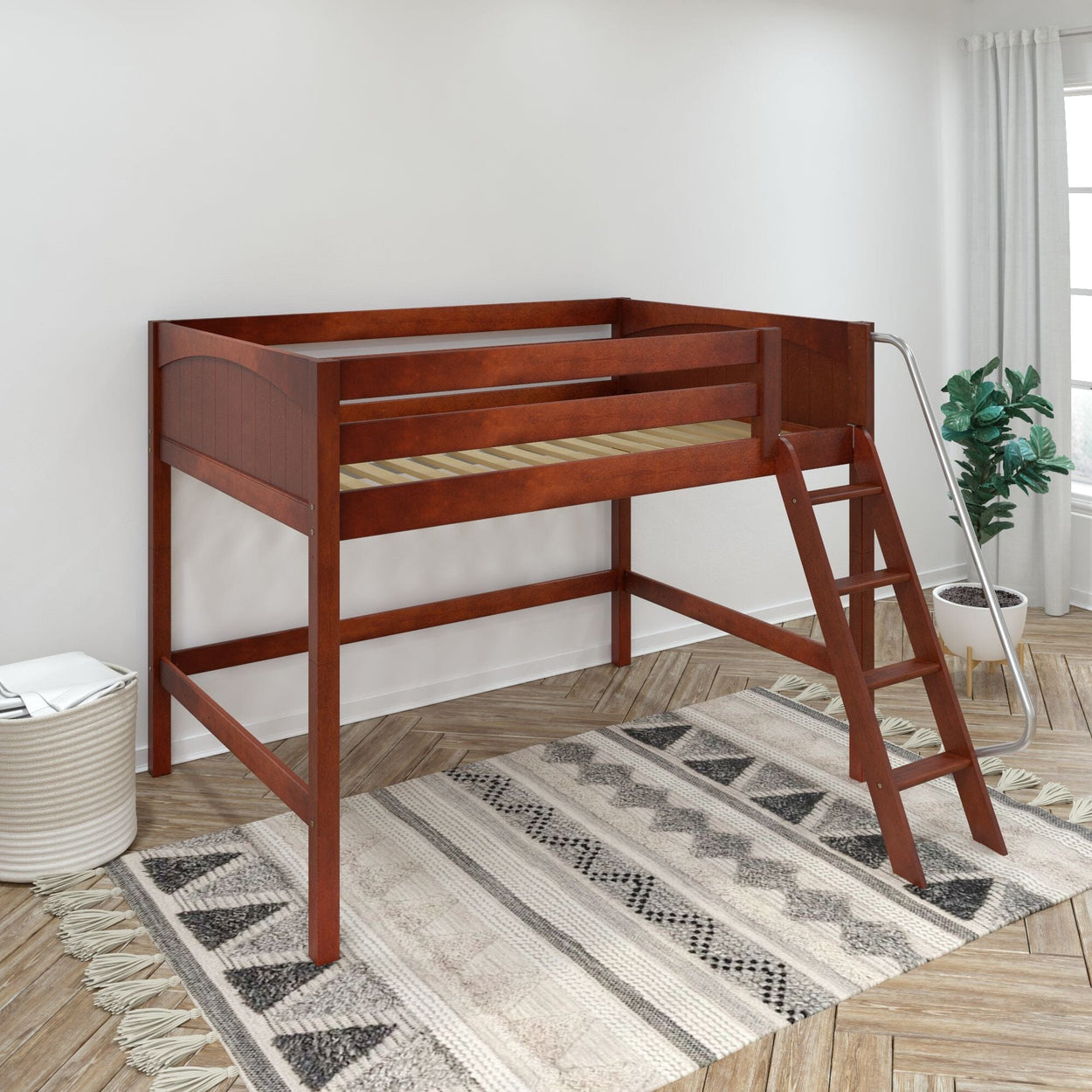 Cherry wood twin loft bed with ladder and safety rails in bright kids' bedroom, patterned rug and potted plant