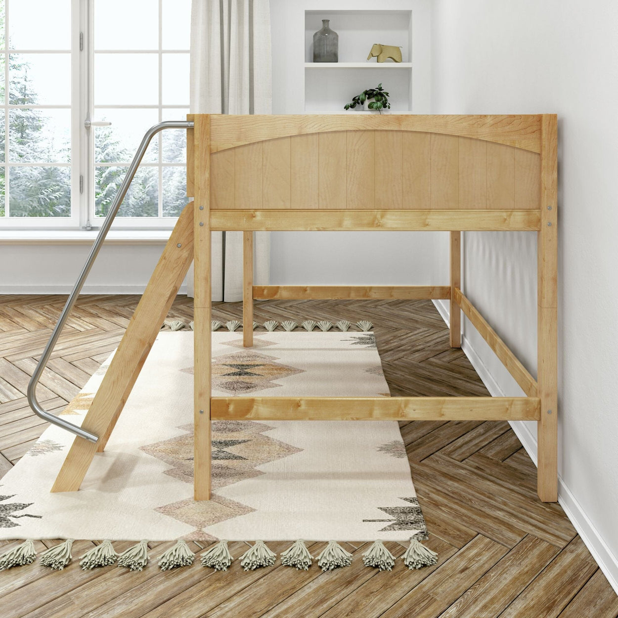 Natural pine loft bed with angled ladder and metal handrail in a bright minimalist kids' bedroom with herringbone wood floor and patterned tassel rug