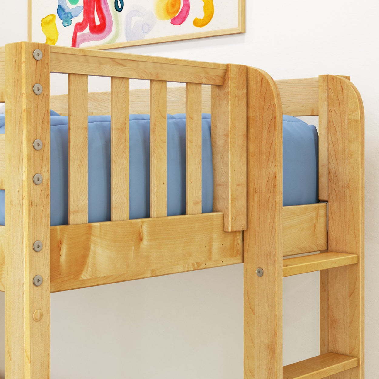 Solid natural wood loft bunk bed with ladder, slatted safety rails and blue twin mattress in a children's bedroom with light maple finish