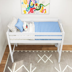White wooden elevated toddler bed with guard rails, blue mattress and star-patterned bedding in kids bedroom with abstract wall art and geometric rug